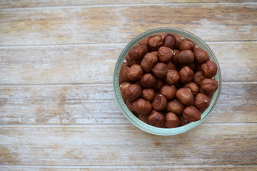 Hazelnuts in a glass jar in the background of the tree. Copy space.