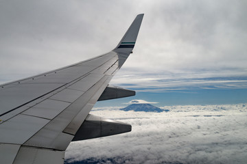 wing of an airplane flying above the clouds