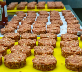Round Pork Cutlets on the Yellow Board Ready to be Cooked for Some Burgers for  Wedding Meal