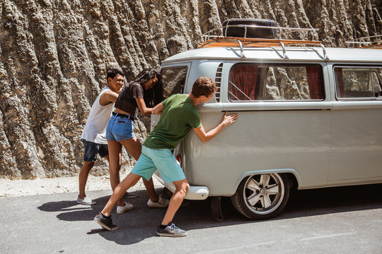 young people feeling tired on the back the broke down car