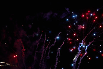 Fireworks in the night sky. Texture salute. Abstract photo of flares on a black background. Photos of lights salute in the sky. Image of salute flashes. Texture of colored lights.