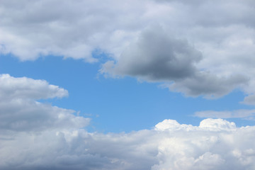 Fototapeta na wymiar Light and dark gray clouds on blue sky center