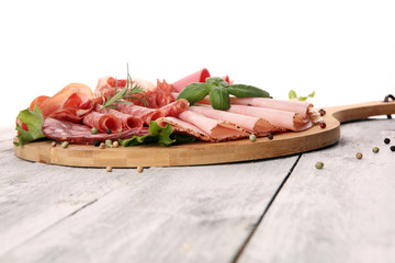 Food tray with delicious salami, pieces of sliced ham, sausage and salad. Meat platter with selection.