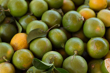tropical south fruit food concept green lemons background texture in market place