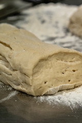 Pile of Homemade Bread Dought on a Table with a lot of Flour Around it