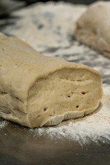Pile of Homemade Bread Dought on a Table with a lot of Flour Around it