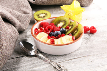 fruit bowl. Bowl of healthy fresh fruit salad on rustic background