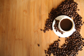 cup of coffee and beans on wooden table