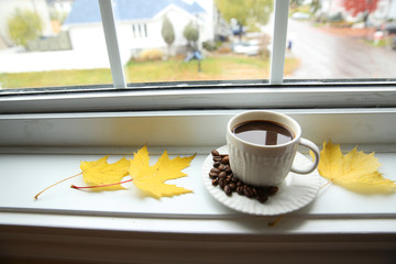 a cup of coffee on the windowsill opposite the window