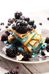 Delicious Tasty Homemade crepes or pancakes with blackberries,blueberries and blue spirulina nicecream.