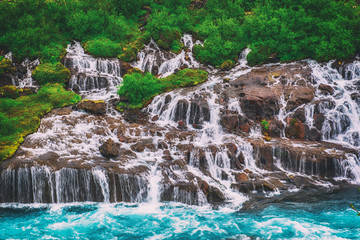 Hraunfossar series of waterfalls formed by rivulets streaming over a distance of about 900 metres....