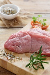 Rohe Schweineschnitzel auf einem Holzbrett
