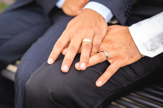 A hand with ring of gay couple in the park on their wedding day