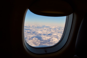 Fototapeta na wymiar Clouds behind airplane window
