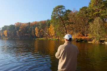 fisherman catching the fish at sunny autumnal day