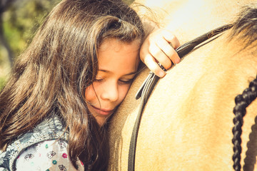 Happy girl are happy and relax with Golden pony on farm, stable, outside. Girl hugging a horse....
