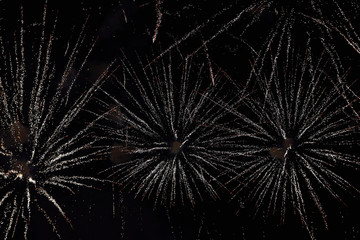 Obraz premium Fireworks in the night sky. Texture salute. Abstract photo of flares on a black background. Photos of lights salute in the sky. Image of salute flashes. Texture of colored lights.