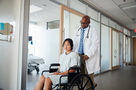 Doctor pushing patient in wheelchair