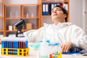 Young biochemist wearing protective suit working in the lab