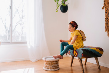 Girl sitting on a stool looking at a golden voucher