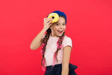 Impossible to resist fresh made donut. Girl hold glazed cute donut in hand red background. Kid playful girl ready to eat donut. Sweets shop and bakery concept. Kids huge fans of baked donuts