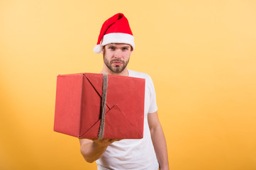 online christmas shopping. Happy new year. delivery christmas gifts. happy santa man on yellow wall. The morning before Xmas. man in santa hat hold christmas present. Merry Christmas. take a parcel