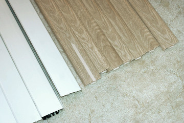 Plinths of various colors are on the carpet. Samples to select the color and texture of the baseboard to the room