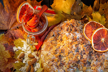 Homemade cakes, nuts, orange, jam decorated with autumn leaves.Autumn background,
