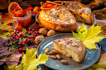 Homemade cakes, nuts, orange, jam decorated with autumn leaves.Autumn background,