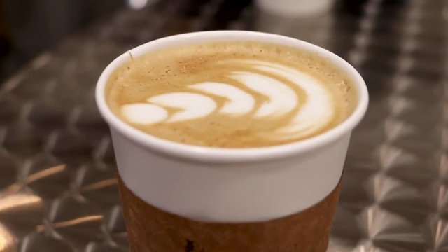 Latte in a coffee shop, camera panning around the drink.