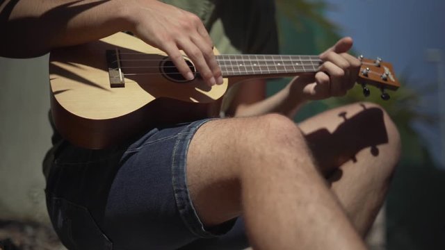 Man Playing a Ukulele Shot From Below