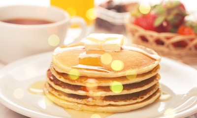 Stack of Small pancakes in syrup on background