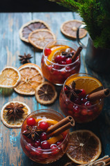 Homemade Christmas mulled red wine with spices, cinnamon and citrus fruit on rustic wooden background, traditional winter hot drink, selective focus