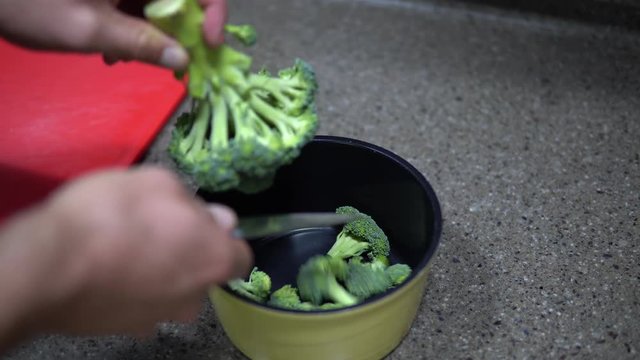 Cutting Healthy Green Organic  Raw Broccoli Florets for  Boiling in Water