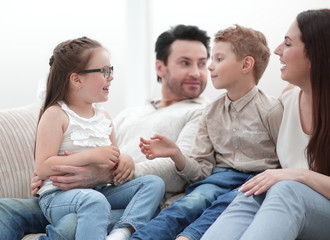 loving parents with children sitting on the couch