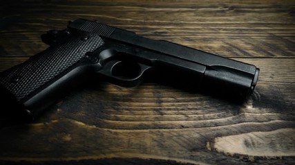 Gloved Hand Picks Up Hand Gun.