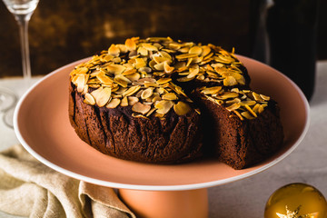 New Year's or Christmas festive chocolate cake with almonds with champagne on the table.