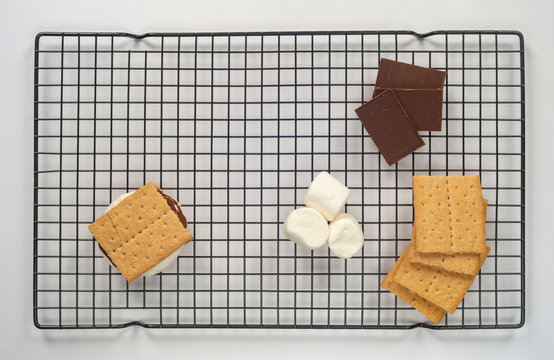 Smores ingredients on a cooling rack flat lay isolated on white