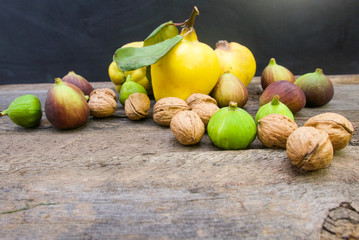 Quince, figs and walnuts with copy space on a rustic wooden table