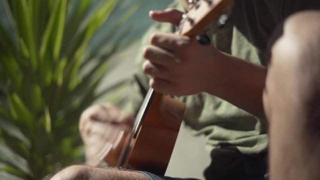Side View of a Man Playing a Ukulele