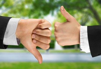 Human hands showing agree sign Versus disagree on background