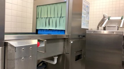 An empty basket coming out of an industrial dish washer. No camera movements. Filmed in realtime at 4k.