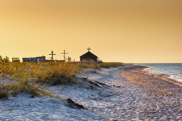 Seaside landscape - sunrise on the seashore with Orthodox Skete against the background of an summer sky