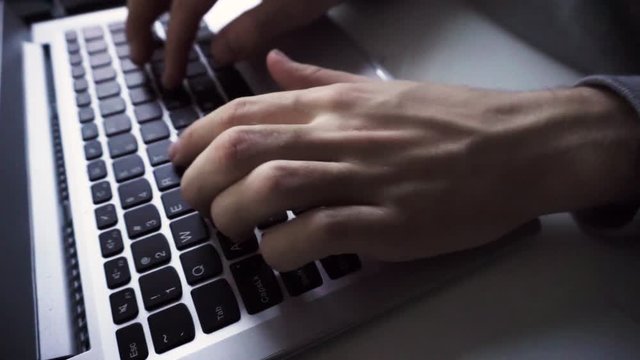 Man typing on laptop keyboard