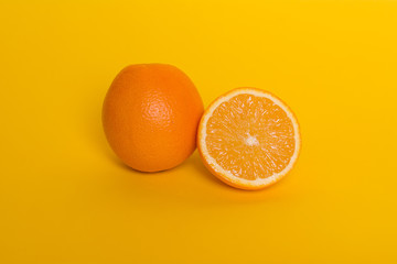 Orange on yellow background. Ripe tropical fruit