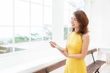 部屋でタブレットを見る女性