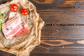 Food background design. Bacon, tomatoes on a dark wooden background. Ingredients.