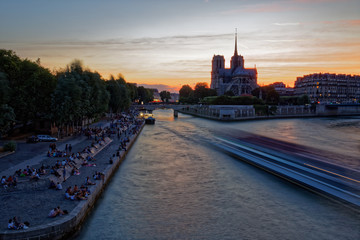 Paris, France - July 5, 2018: Notre Dame Cathedral with Paris cityscape and River Seine at dusk, France