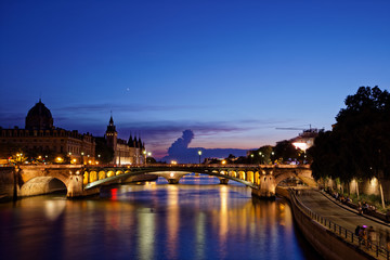 Fototapeta na wymiar Paris, France - July 5, 2018: Conciergerie with Paris cityscape and River Seine at dusk, France