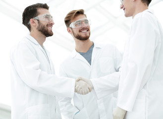 blurred image of a handshake between scientists